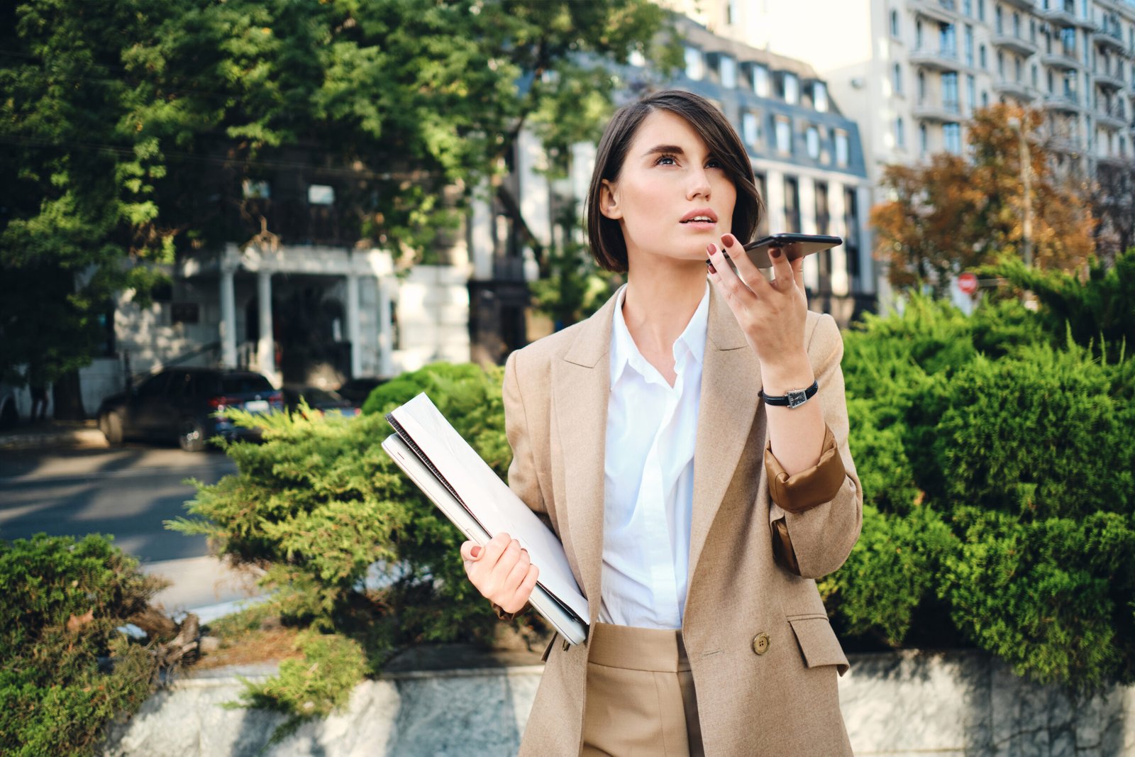 young attractive businesswoman in beige suit with laptop thought